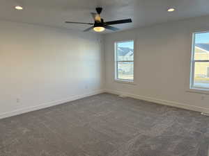 Master bedroom Spare room with recessed lighting, dark colored carpet, healthy amount of natural light, and ceiling fan