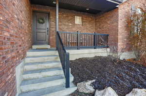 Property entrance with brick siding and a porch