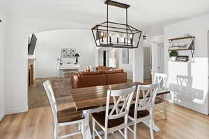 Dining room featuring a fireplace, light wood-style flooring, and a chandelier