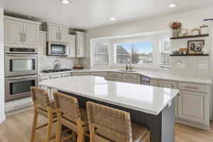 Kitchen featuring stainless steel appliances, a breakfast bar area, a kitchen island, decorative backsplash, and recessed lighting