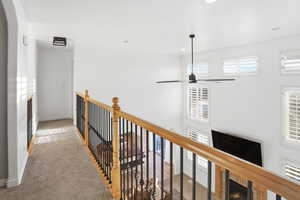 Hallway featuring carpet, an upstairs landing, and recessed lighting