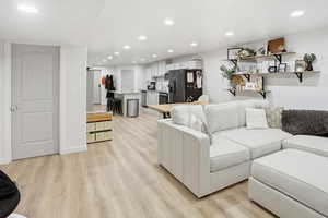 Living area with recessed lighting and light wood finished floors
