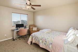 Bedroom featuring an office area, carpet, and ceiling fan
