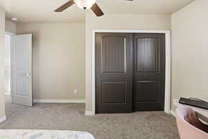 Bedroom featuring light carpet, a closet, and a ceiling fan
