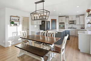 Dining room with light wood-style flooring, recessed lighting, and a chandelier
