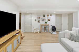 Living room with recessed lighting and light wood-style floors