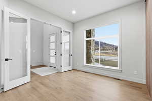 Foyer featuring french doors, light wood-style floors, a mountain view, and recessed lighting
