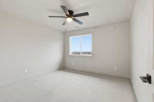 Empty room with carpet flooring and a ceiling fan