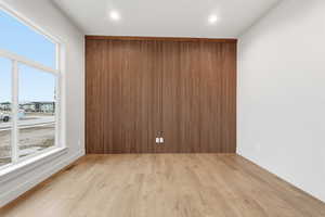 Spare room with light wood-style floors, recessed lighting, and an accent wall