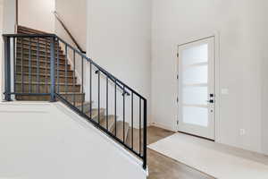 Foyer featuring stairs, wood finished floors, and a high ceiling