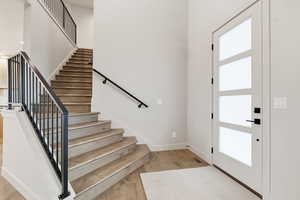 Entrance foyer featuring light wood-style floors and stairs