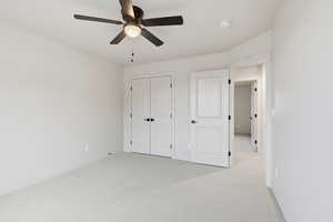 Unfurnished bedroom featuring carpet floors, a ceiling fan, and a closet