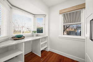Office area featuring dark wood-type flooring and baseboards