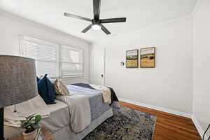 Bedroom featuring crown molding, wood finished floors, and ceiling fan