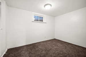 Carpeted empty room with a textured ceiling