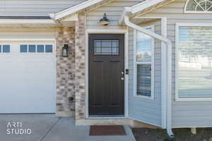 Property entrance featuring stone siding and brick siding