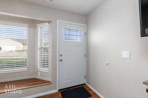 Foyer entrance featuring dark wood-style flooring and baseboards