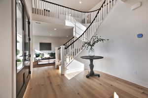 Foyer with light wood-style floors, a high ceiling, and recessed lighting
