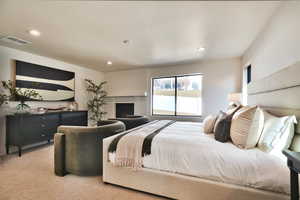 Bedroom featuring a brick fireplace, light colored carpet, and recessed lighting