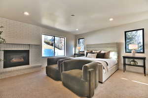 Bedroom featuring light carpet, a brick fireplace, and recessed lighting