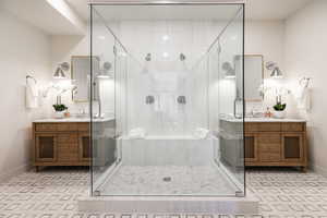 Full bath with two vanities and a stall shower