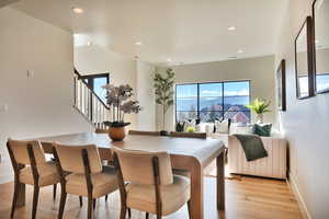 Dining space with light wood finished floors and recessed lighting