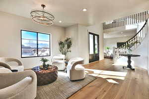 Entrance foyer with hardwood / wood-style floors, hanging lights, and french doors