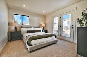 Bedroom with access to exterior, light colored carpet, and recessed lighting