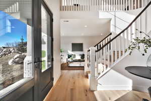 Entryway featuring light wood-type flooring and a high ceiling