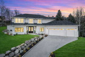 View of front of home featuring a lawn, a garage, french doors, and driveway