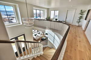 Stairway with hardwood / wood-style flooring and a chandelier