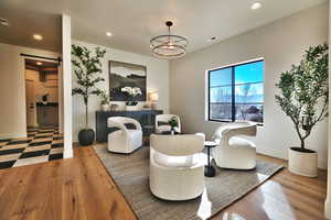 Living area featuring a barn door, wood-type flooring, and hanging lights