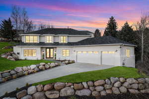 View of front of house with an attached garage, a front lawn, concrete driveway, and french doors