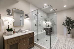 Full bathroom featuring vanity, a shower stall, and recessed lighting