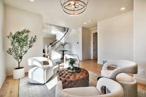 Living area with light wood-type flooring and recessed lighting