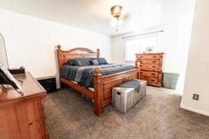 Carpeted bedroom with a ceiling fan