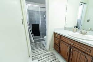 Bathroom with vanity, a stall shower, and light tile patterned flooring