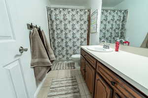 Full bathroom with a shower with curtain, vanity, and light tile patterned floors
