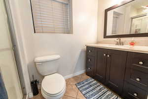 Full bathroom with vanity, a shower stall, and light tile patterned flooring