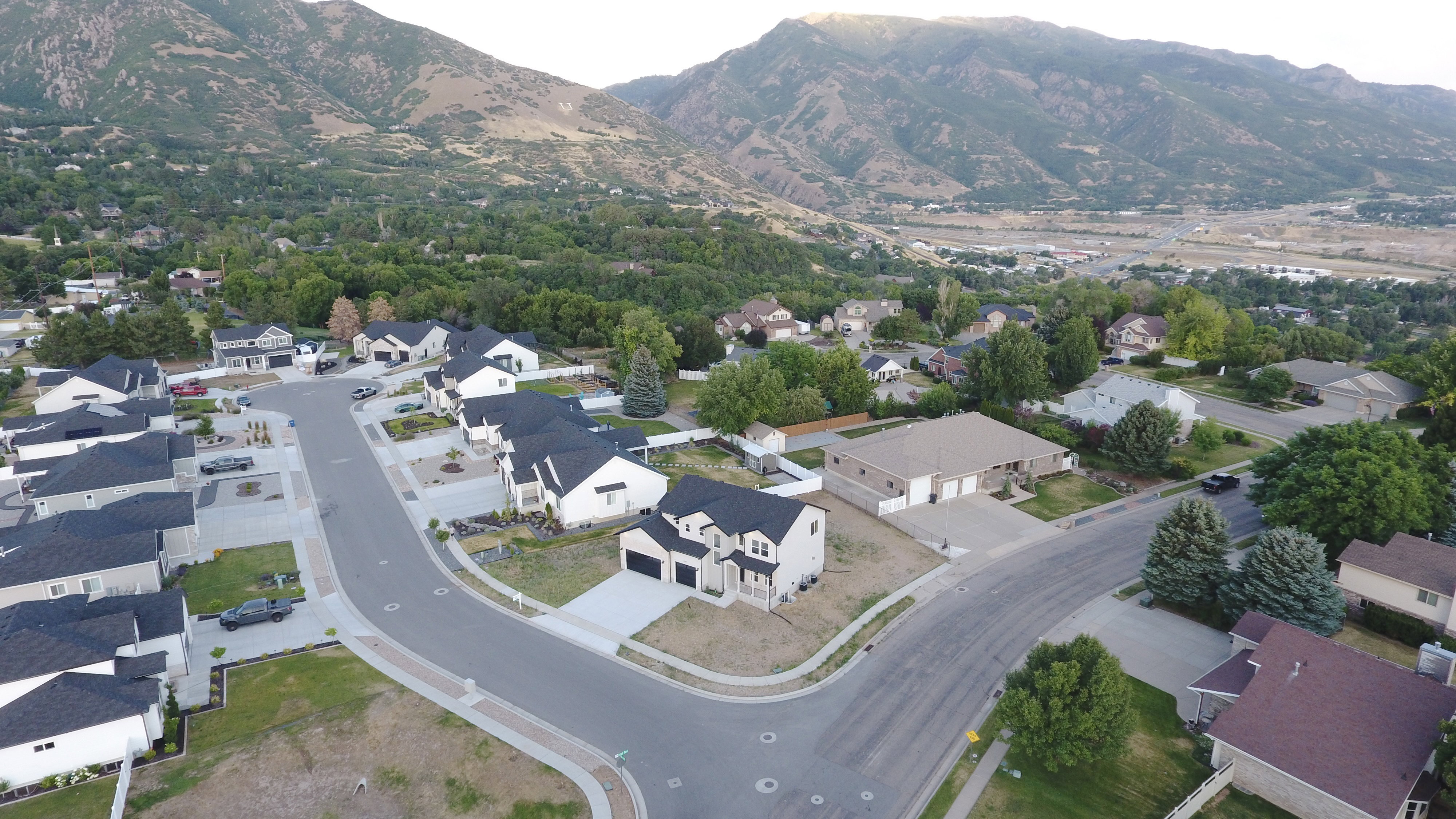 Contemporary residential neighborhood featuring single-family homes with dark-pitched roofs and light-colored exteriors