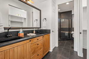 Full bathroom featuring double vanity, a shower stall, dark tile patterned flooring, a closet, and recessed lighting
