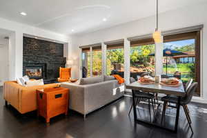 Living room with a fireplace, dark wood-style floors, and recessed lighting