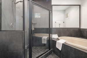 Bathroom featuring a garden tub, a stall shower, and tile patterned flooring