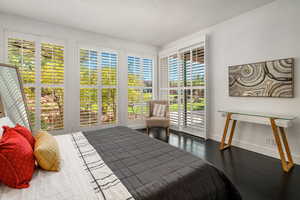 Bedroom with access to outside and dark wood finished floors