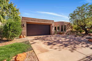View of front of property with driveway, stucco siding, and a garage