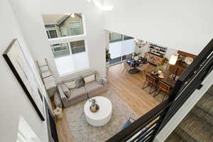 Living area featuring wood finished floors, a high ceiling, and a chandelier