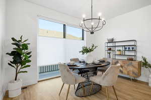 Dining space with light wood-type flooring and a chandelier