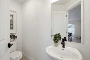 Half bath with a sink and baseboards