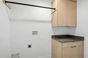Laundry room with cabinet space, hookup for a washing machine, and hookup for an electric dryer