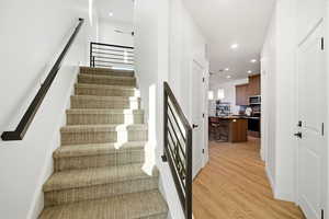 Stairway featuring recessed lighting and wood finished floors
